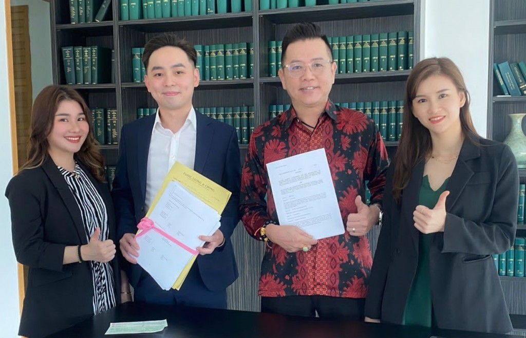 Michael (second left) and M Ryann (second right) holding the signed documents while flanked by Audrey (left) and Rainie (right).