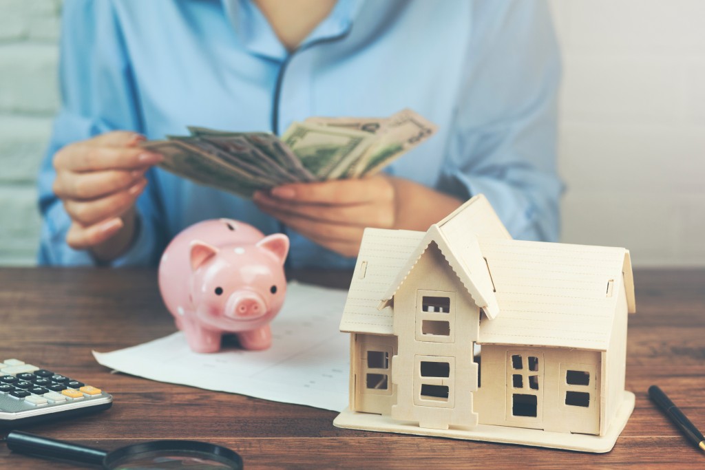 woman hand money with house model