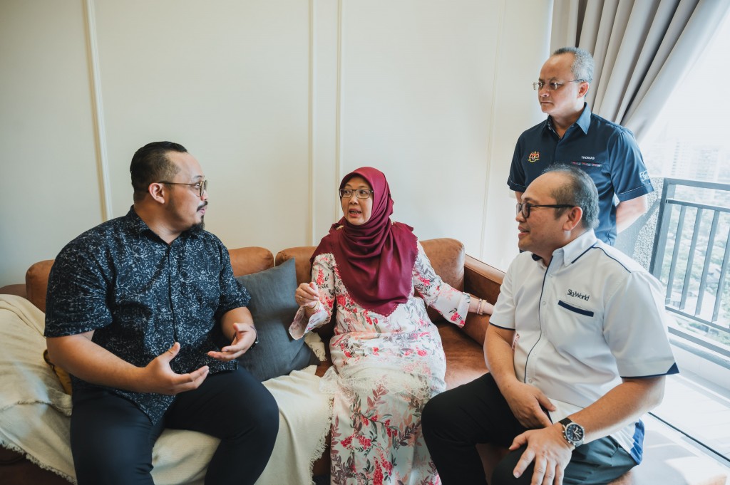 Zaliha (centre) spoke to a new homeowner of SkyAwani 5 Residences at the showroom unit while Lee (right) and Parang (standing) listened attentively. 