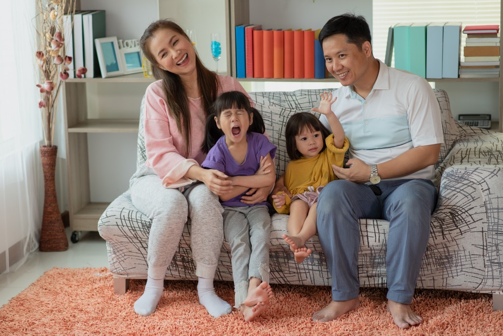 Happy Asian family mother and father with two daughters playing