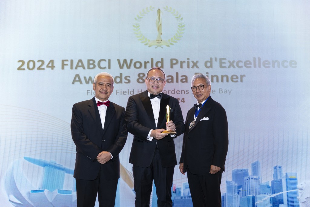 Lee (centre) receiving the award from Budiarsa (right) as Soelaeman looks on.