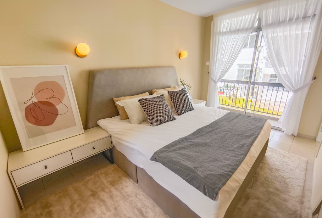 The floor-to-ceiling windows allow for maximum natural lighting into the bedroom.